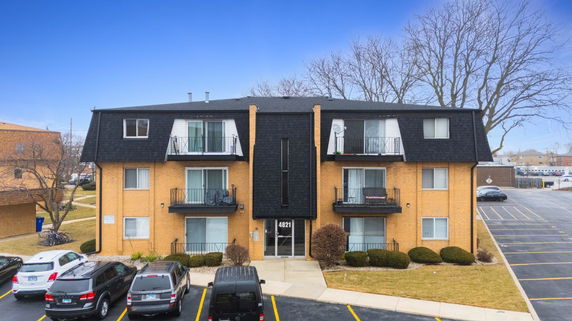 Front view of a three-story apartment building with balconies.