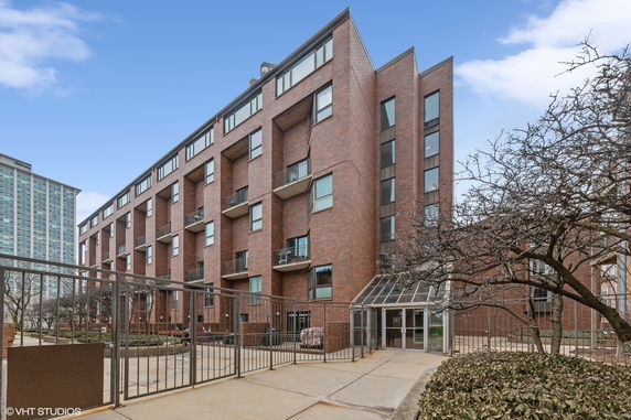 Front view of a multi-story brick building with balconies.