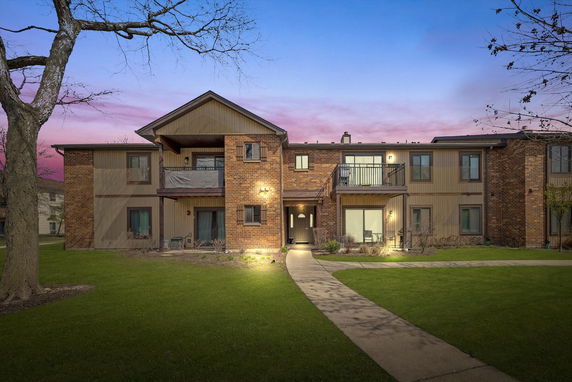Front view of a two-story brick apartment building with balconies.