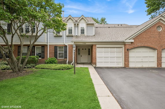 Front view of a two-story house with attached garage and brick facade.