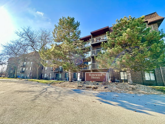 Front view of a multi-story apartment building with balconies.