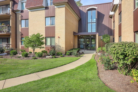 Front view of a multi-story building with a brown and beige exterior.