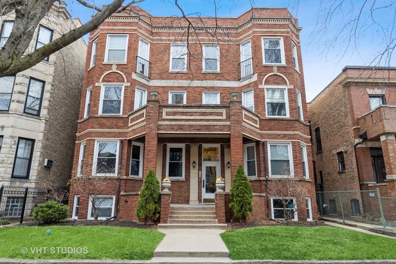 Front view of a three-story brick building with decorative trim.