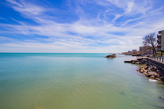 Wide-angle view of a waterfront area with a clear blue sky and calm waters.
