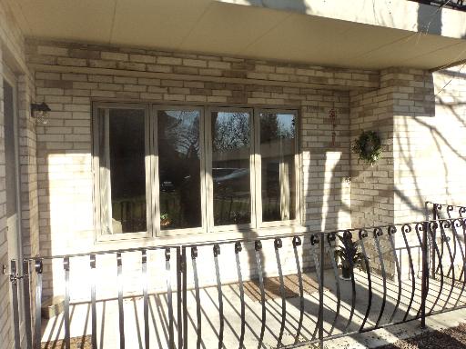 Front view of a house with brick exterior and a railing on the porch.