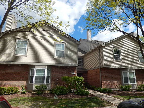 Front view of a two-story house with brick and siding exterior.