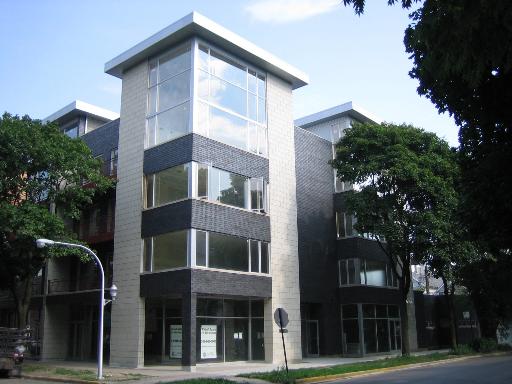 Front view of a modern multi-story building with large windows.