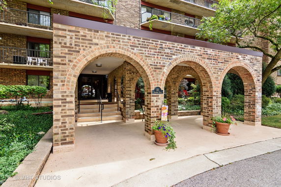 Front view of a multi-story brick building with arched entrance.