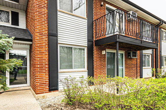 Front view of a two-story building with a brick facade and balcony.
