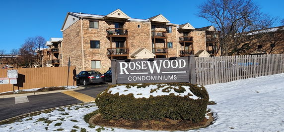 Front view of a brick condominium building with balconies.