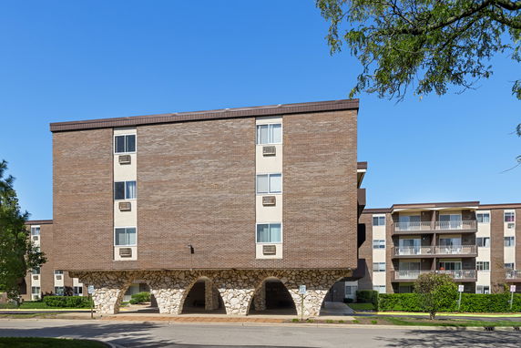 Front view of a multi-story building with stone arches and brick facade.