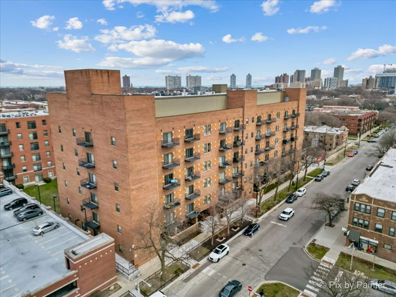 Front view of a multi-story brick apartment building with balconies.