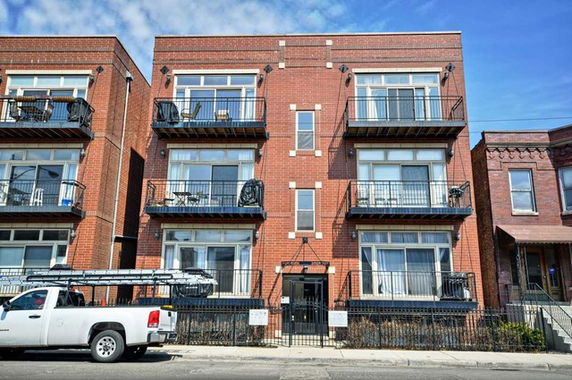 Front view of a multi-story brick building with multiple balconies.