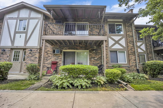 Front view of a two-story brick building with decorative paneling and balconies.