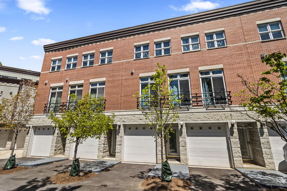 Front view of a multi-story brick building with multiple garages.