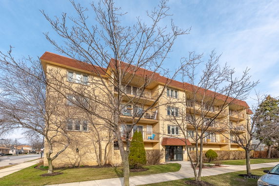 Front view of a four-story apartment building with balconies.