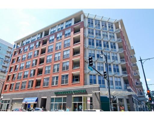 Front view of a multi-story mixed-use building with retail stores at the ground level.