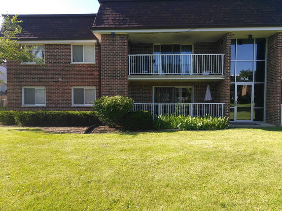 Front view of a two-story brick apartment building with balconies.