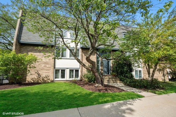 Front view of a two-story house with a sloped roof and brick exterior.