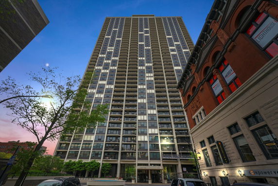 Front view of a tall residential building with multiple balconies.