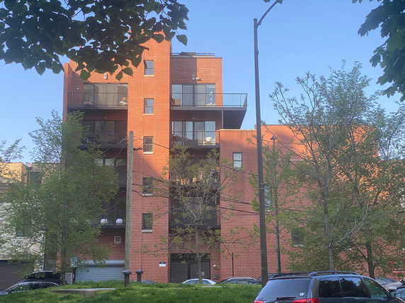 Front view of a multi-story brick building with balconies.