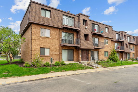Front view of a multi-story apartment building with balconies.