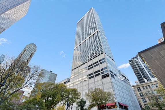 Front view of a tall skyscraper with a grid-like facade.