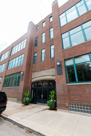 Front view of a multi-story brick building with large windows and an entrance labeled 'Teletype'.