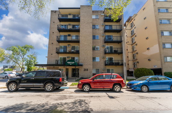 Front view of a multi-story apartment building with balconies.