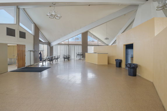 Interior of a spacious community club house with high ceilings and seating areas.