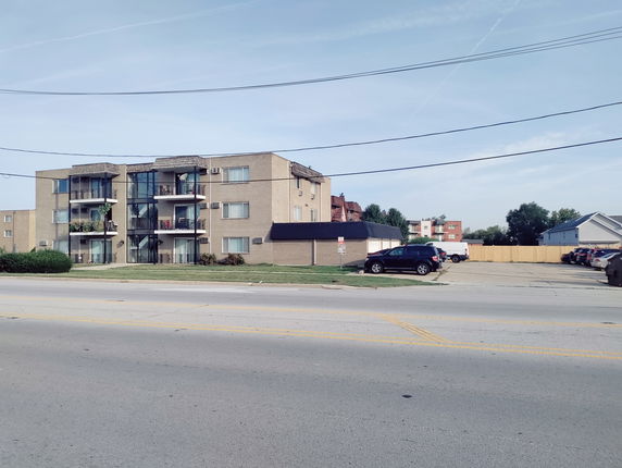 Front view of a multi-story apartment building with balconies.