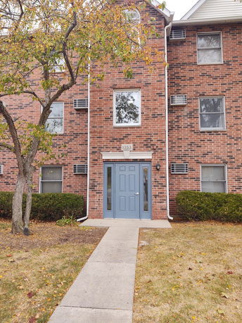 Front view of a brick apartment building with a blue door.