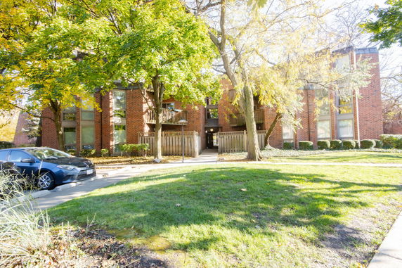 Front view of a multi-story brick apartment building with balconies.