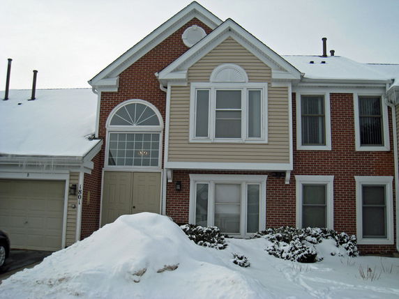 Front view of a two-story house with brick and siding exterior.