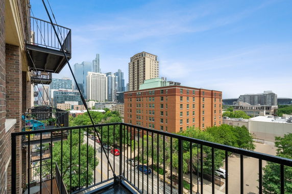 View of surrounding cityscape with multiple buildings from a balcony perspective.