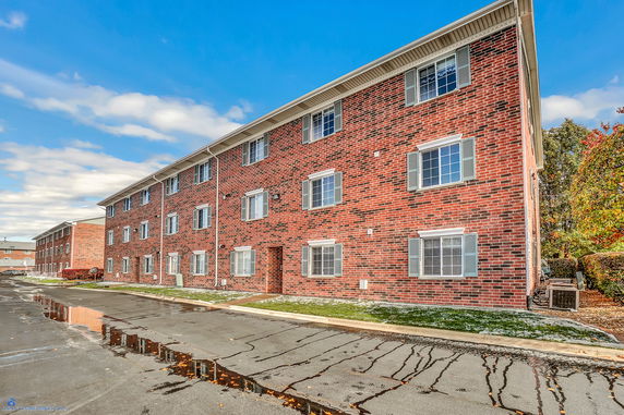 Front view of a multi-story brick apartment building.