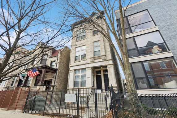 Front view of a multi-story residential building with a stone facade.