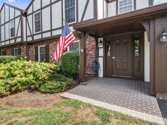 Front view of a house with a brick facade and decorative wooden trim.