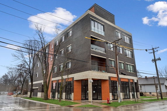 Front view of a multi-story building with modern design and large windows.
