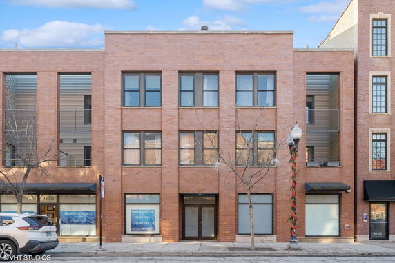 Front view of a brick commercial building with multiple windows and a central entrance.