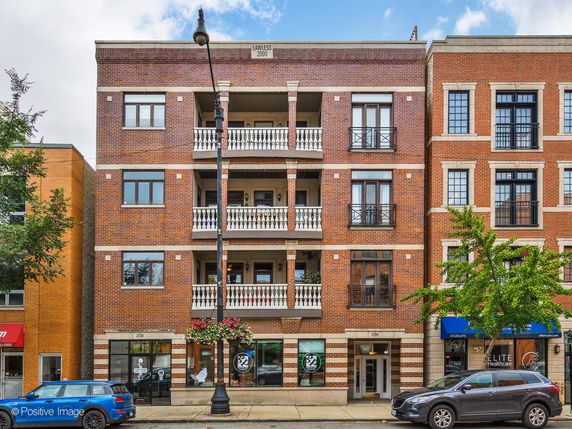 Front view of a multi-story brick building with balconies.