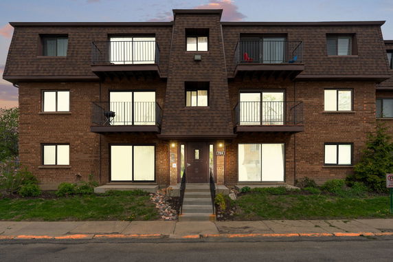 Front view of a three-story brick building with balconies.