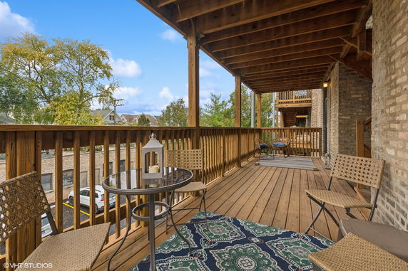 Wooden deck with seating overlooking surrounding area.