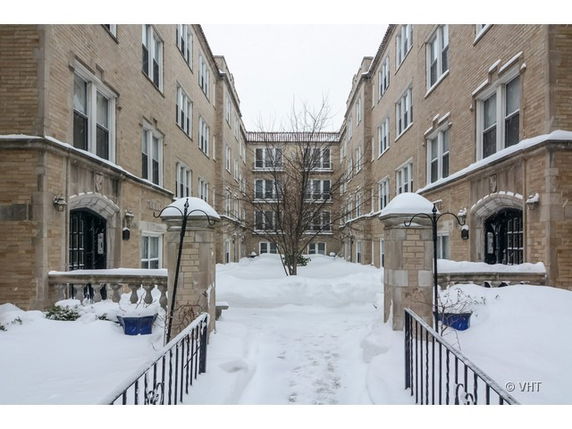 Front view of a multi-story residential building complex covered in snow.