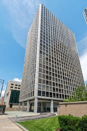 Front view of a tall office building with a grid-like facade.
