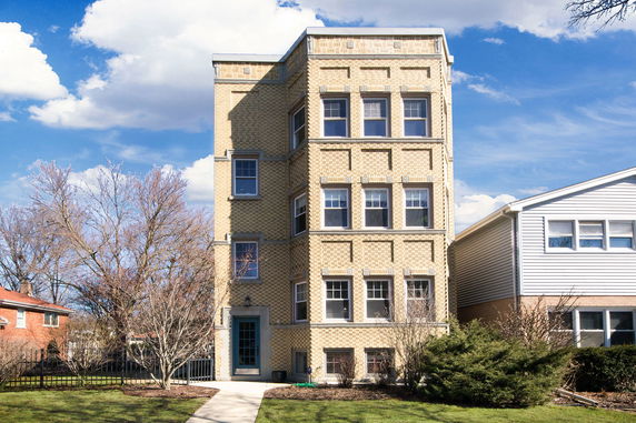 Front view of a narrow, multi-story brick building with symmetrical windows.