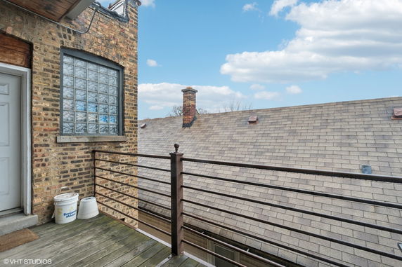 Rooftop view with chimney and metal railing.
