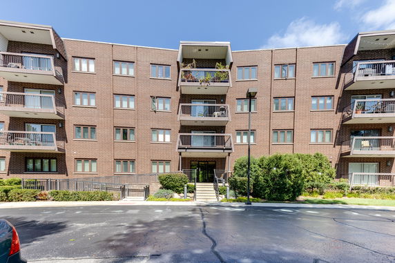 Front view of a multi-story brick building with balconies.