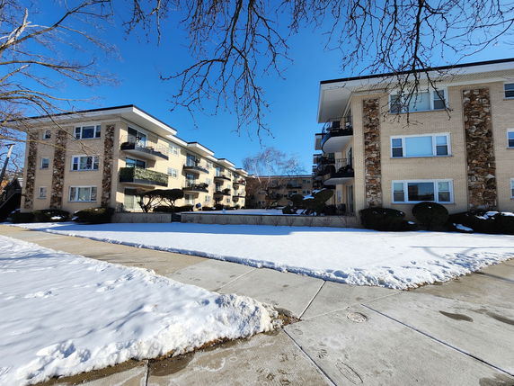 Front view of a three-story apartment building with balconies.