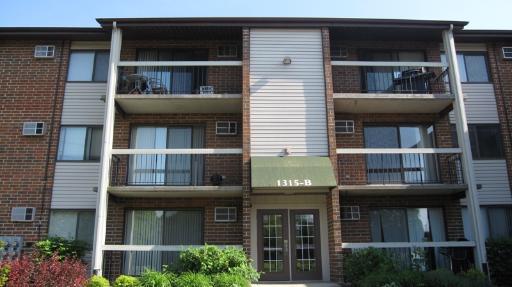 Front view of a multi-story apartment building with balconies.
